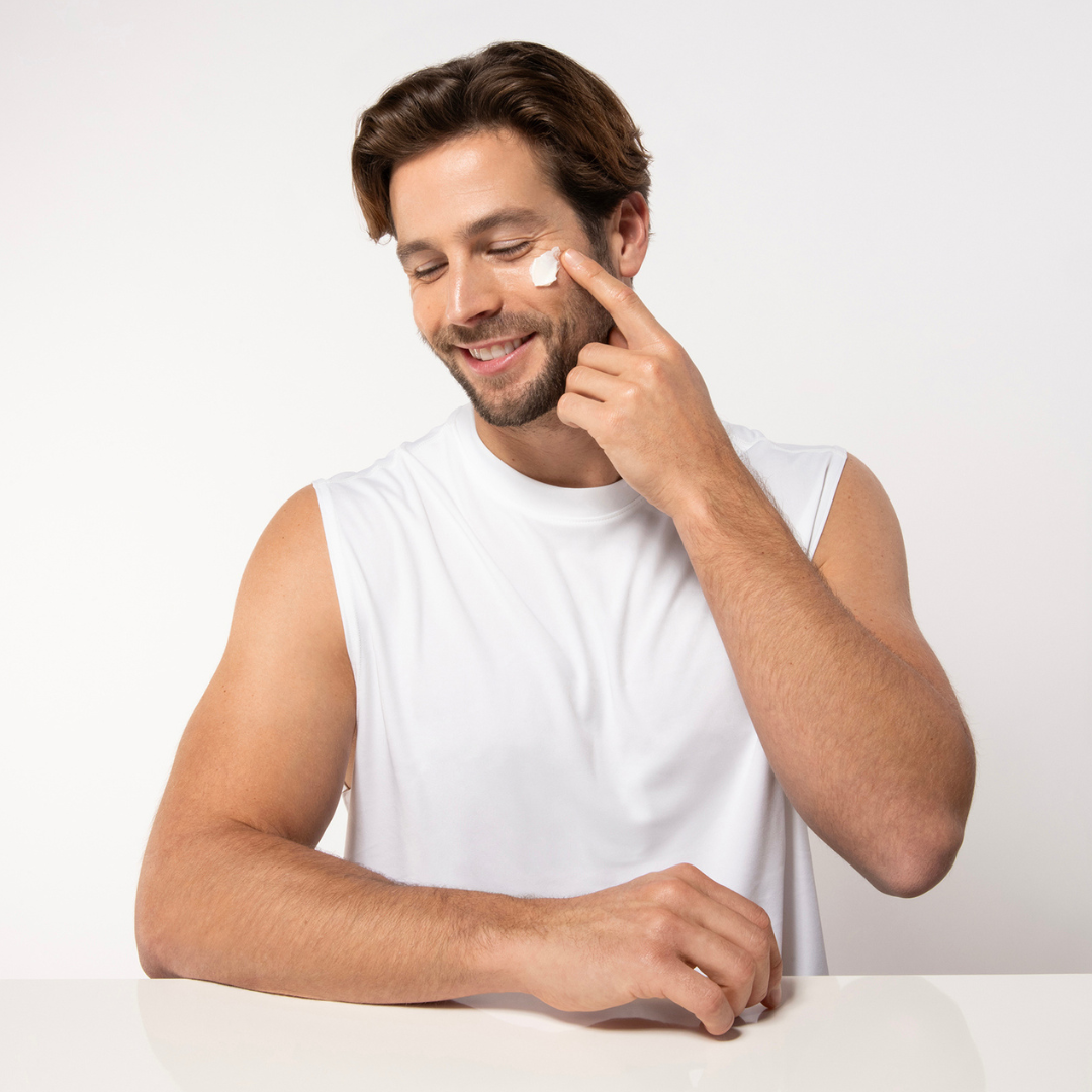 Man applying cream to his face on a white background